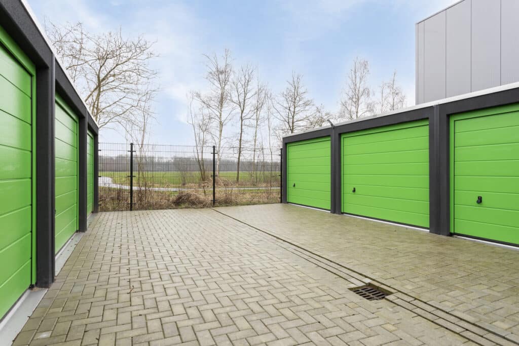 Garageboxen met overheaddeuren en hekwerk.